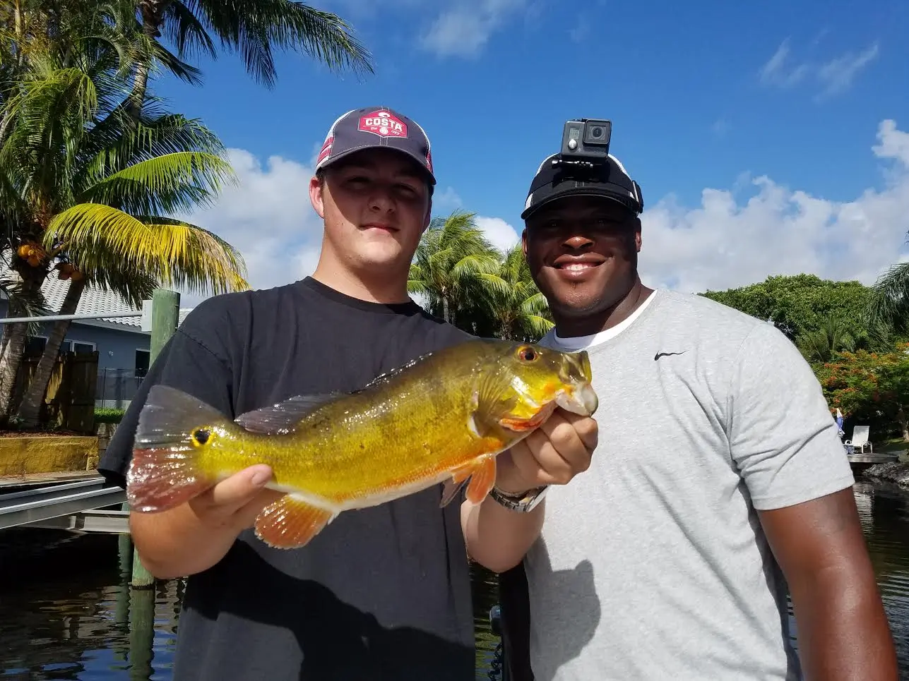 Two anglers holding a peacock bass