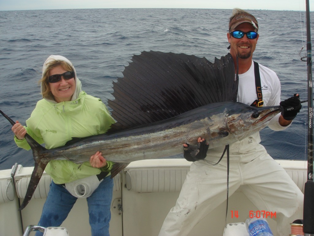 Angler holding a sailfish on an offshore charter boat