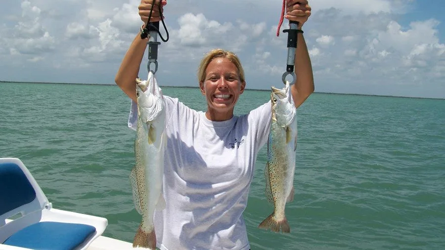 Angler holding two spotted seatrout on a Daytona Beach inshore charter