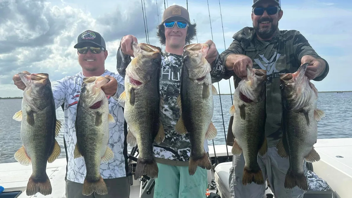 Three anglers holding big largemouth bass on Lake Okeechobee