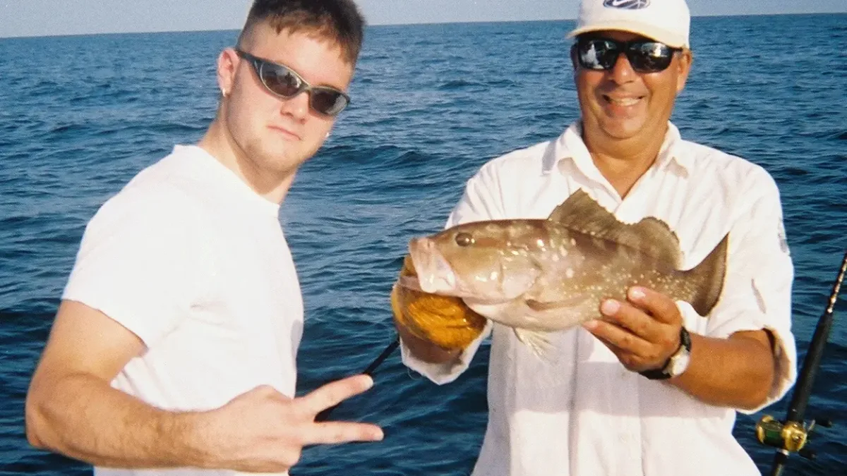 Angler and captain holding a grouper off Tampa Bay